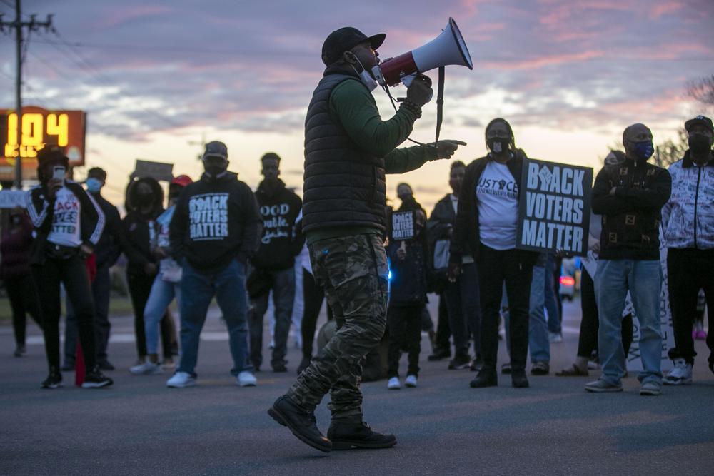 A man with a megaphone addresses demonstrators during a march on Friday in Elizabeth City, N.C.