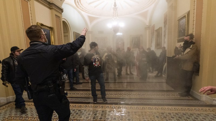 Smoke fills the walkway outside the Senate Chamber as supporters of President Donald Trump are confronted by U.S. Capitol Police officers inside the Capitol in Washington