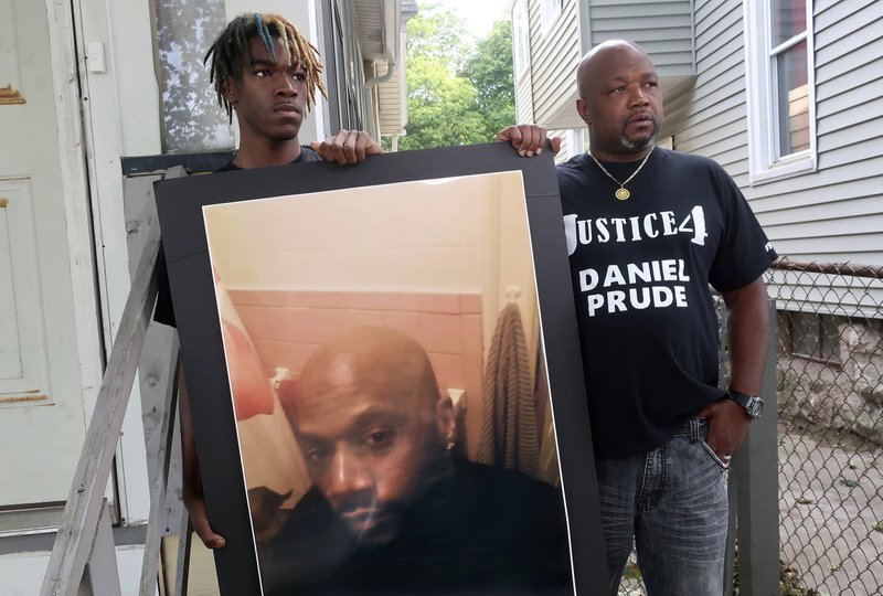 Joe Prude, right, uncle of Daniel Prude, and Daniel's nephew Armin, pictured last September in Rochester, N.Y. with a picture of Daniel Prude