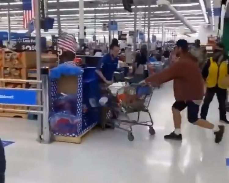 shopper pinning Walmart worker to display case with trolley