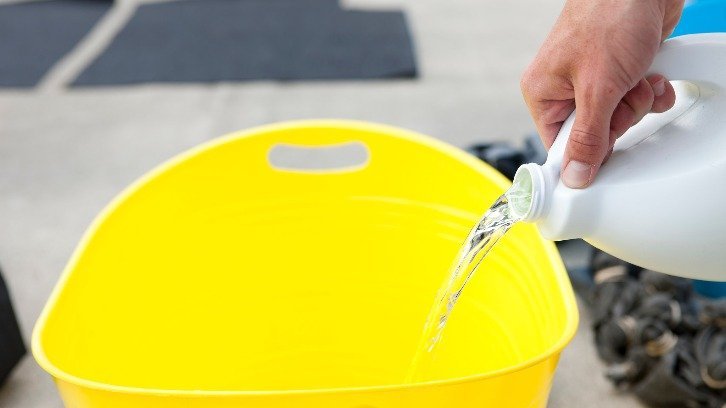 bleach being poured into yellow bucket