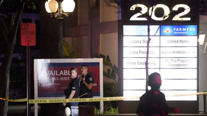 Police officers stand outside an office building in Orange, California, where a shooting occurred Wednesday