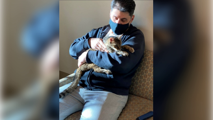 Brandy, a brown tabby cat who vanished 15 years, back in the arms of her owner, Charles, at an animal care center in Palmdale, California