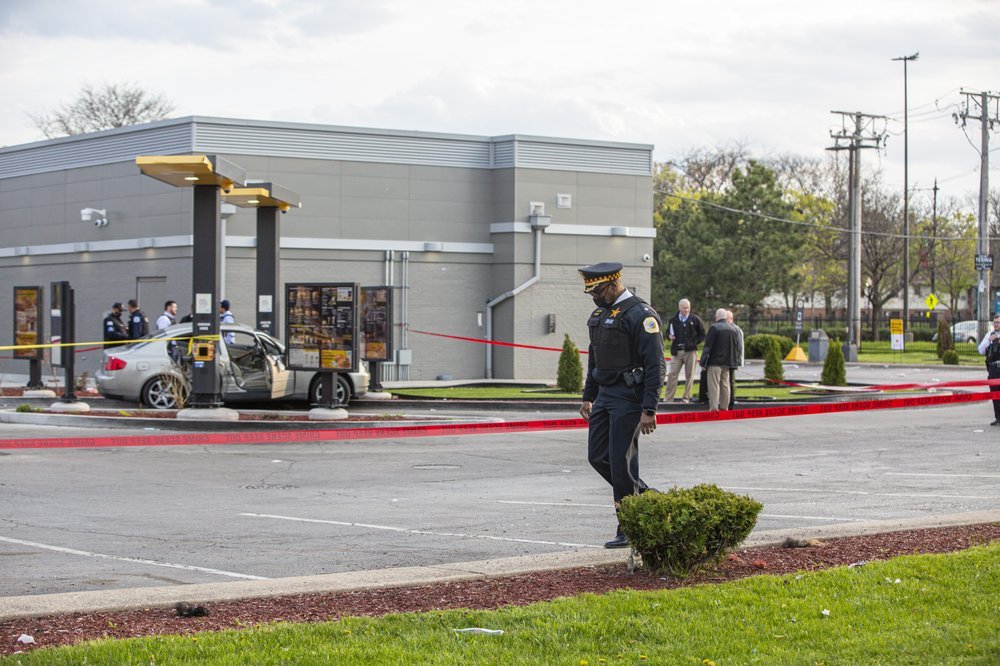 Police investigate a crime scene at a McDonald’s drive-thru in Chicago, where Jontae Adams, 28, and his 7-year-old daughter Jaslyn were shot, resulting in Jaslyn’s death