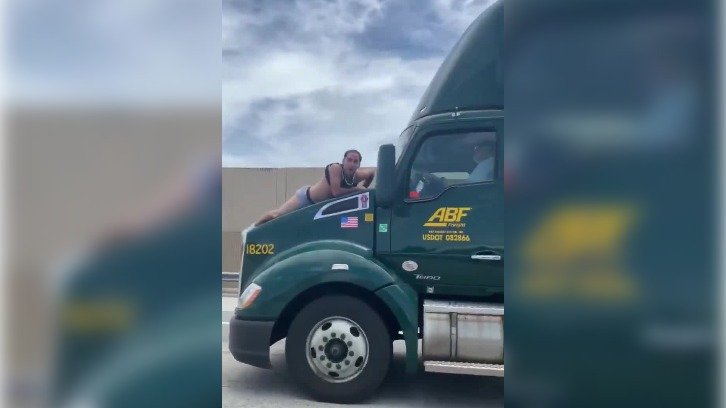 Screengrab of video showing the unidentified man clinging to the hood of a moving semi-trailer on a Florida highway