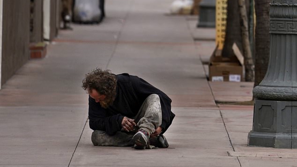 A homeless man sitting on the sidewalk outside Union Station in Los Angeles late last week