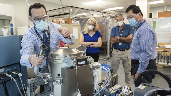 Astronaut Kate Rubins and support personnel reviewing the Universal Waste Management System, a low-gravity space toilet, in Houston